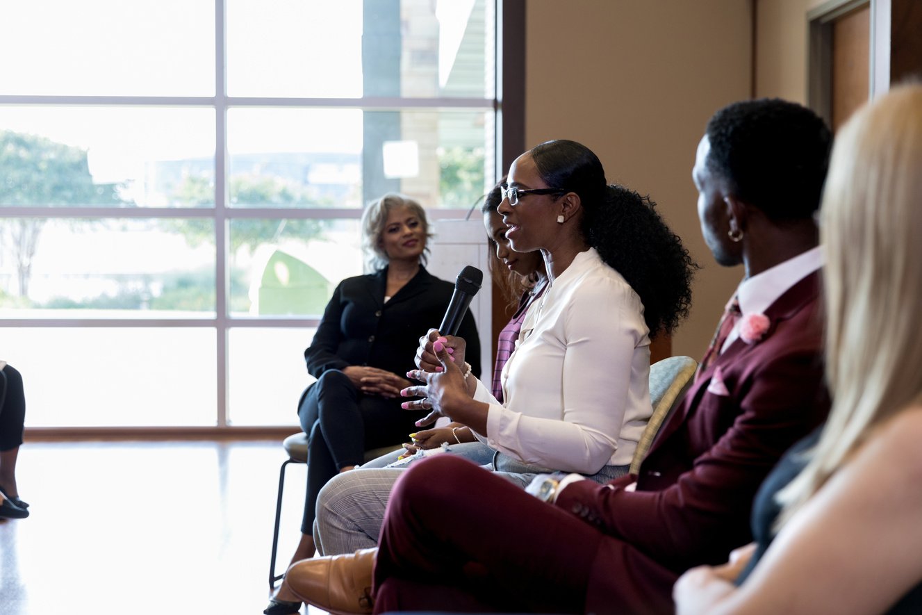 Mid adult female panel member gestures and speaks